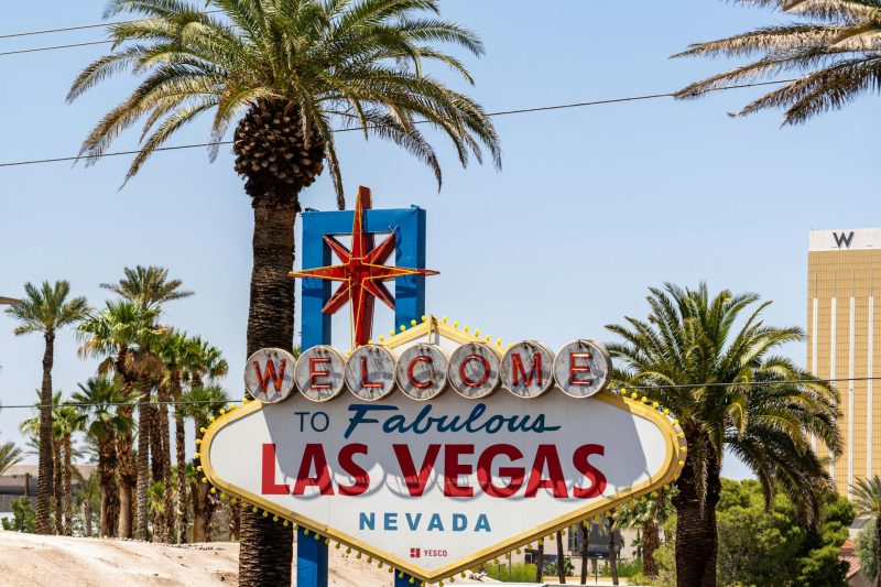 Classic "Welcome to Las Vegas" sign with palm trees under a clear blue sky.