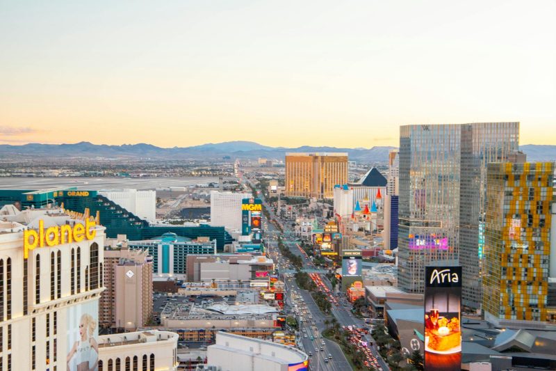 Aerial view of the Las Vegas Strip at sunset, highlighting iconic hotels and casinos with a vibrant sky.