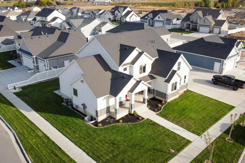 Aerial view of modern homes with manicured lawns in a residential area of Spanish Fork, Utah.