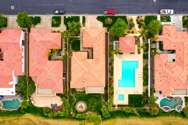 Aerial view of suburban homes with private pools, showcasing a luxurious lifestyle in La Quinta, California.